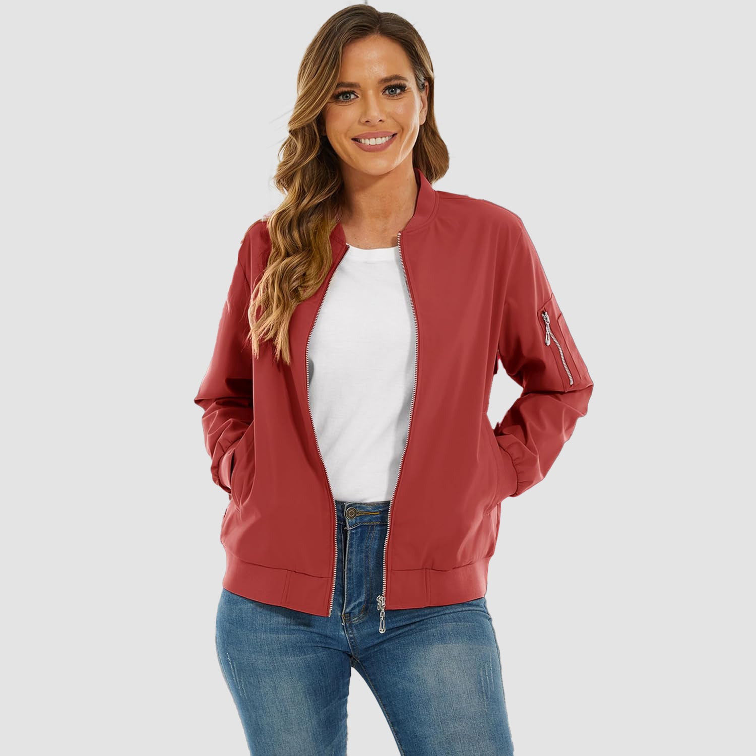 Red lightweight bomber jacket in water-resistant polyester with a zip sleeve pocket, ribbed trim, and front zip closure.
