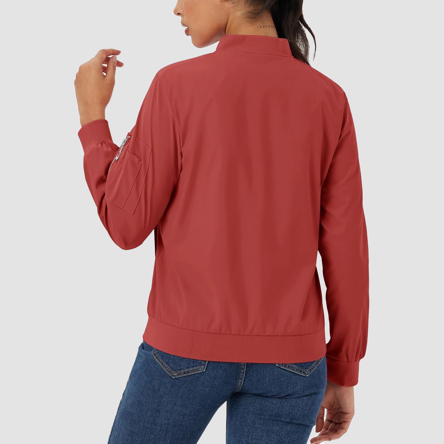 Red lightweight bomber jacket in water-resistant polyester with a zip sleeve pocket, ribbed trim, and a classic fit.