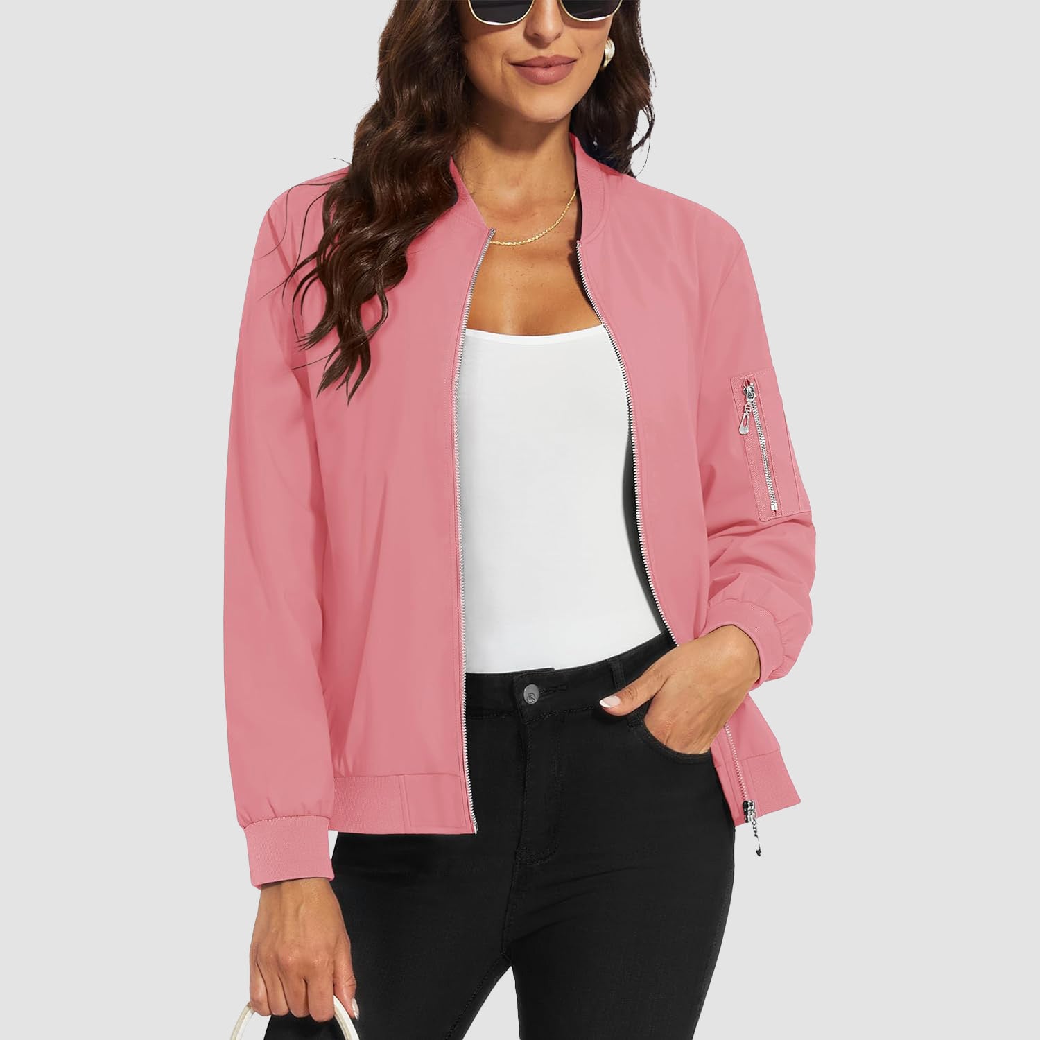 Lightweight pink bomber jacket in water-resistant polyester with a zip sleeve pocket, ribbed trim, and a zip-up front.