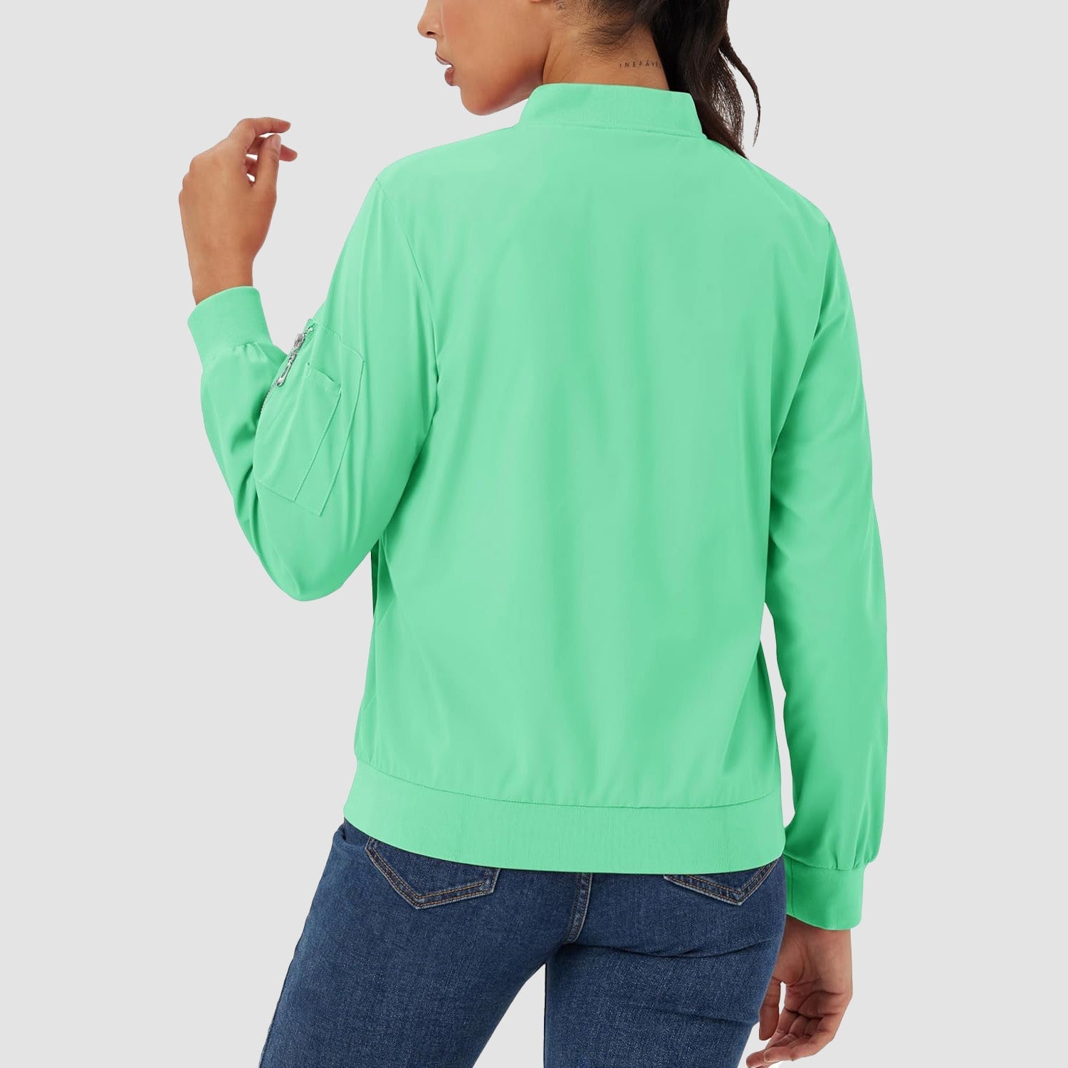 Light green lightweight bomber jacket with a zip sleeve pocket, ribbed trim, and a smooth, water-resistant finish.