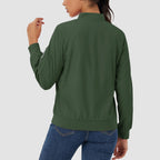 Dark green lightweight bomber jacket with a zip sleeve pocket, ribbed trim, and water-resistant finish worn with jeans.
