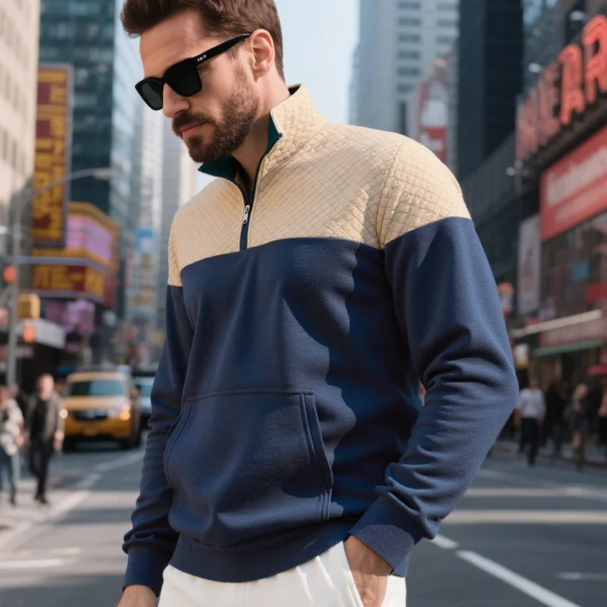 Navy and beige color-block quarter-zip fleece pullover with a stand collar and kangaroo pocket, worn with sunglasses for a casual city look.