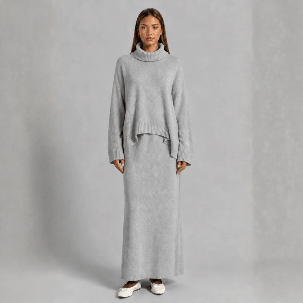 Full-length front view of a model wearing the light gray knit co-ord set featuring an oversized turtleneck sweater and column maxi skirt.