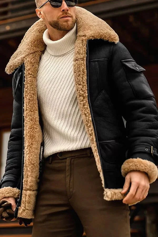 Black leather aviator jacket with a plush tan shearling collar, padded lining, and flap pockets worn over a white turtleneck.