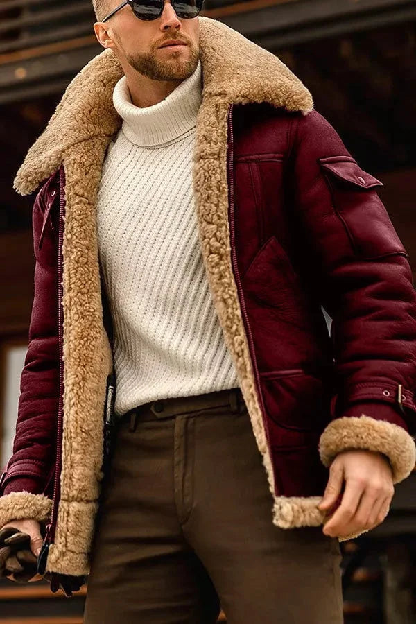 Burgundy leather aviator jacket with a plush shearling collar, padded lining, and flap pockets worn over a cream turtleneck.