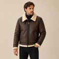 A man wearing a brown leather aviator jacket with a shearling collar, zip front, and shearling-trimmed cuffs and hem