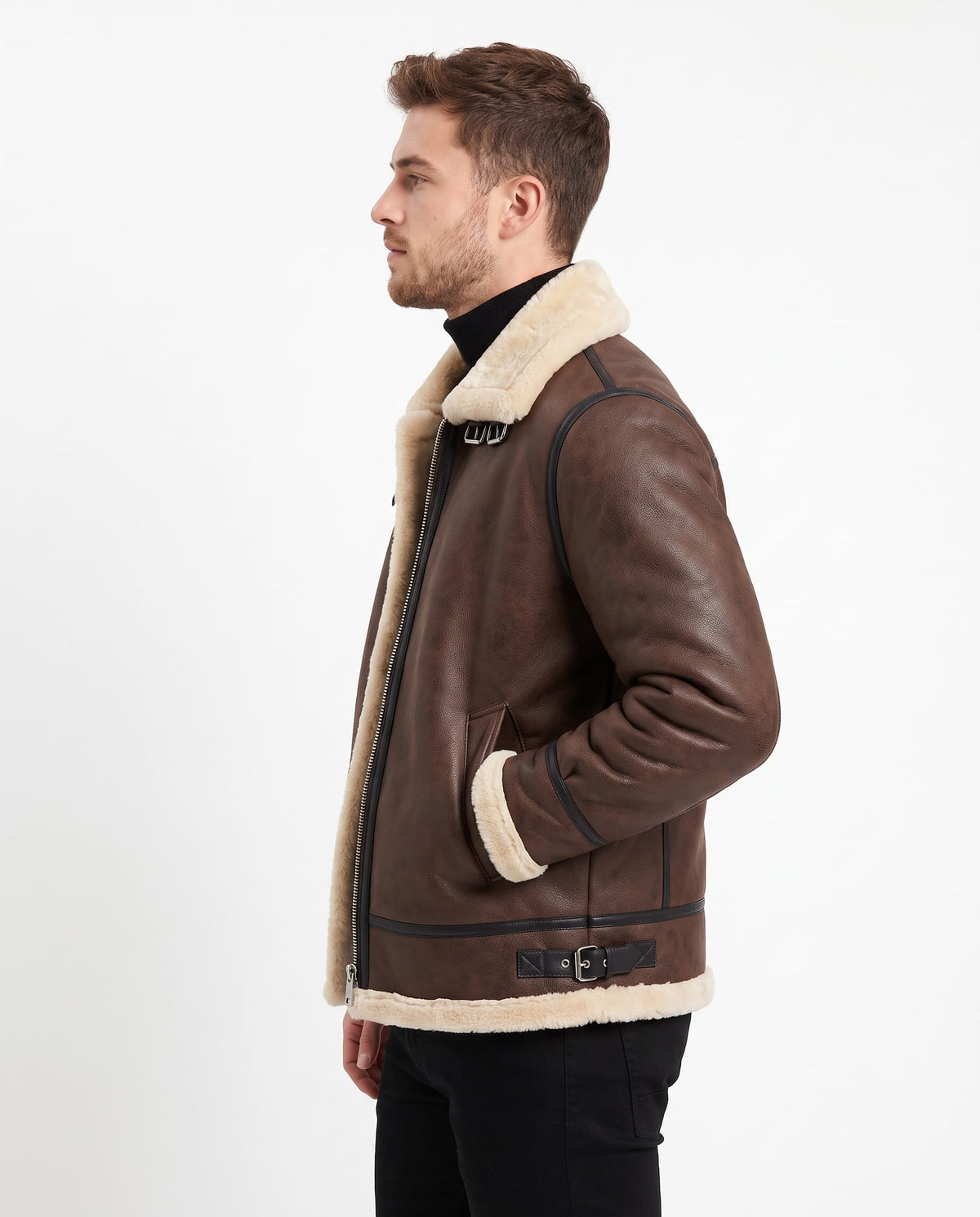 Brown leather aviator jacket with cream shearling lining, asymmetric zip closure, and side buckle details.