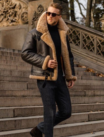 A man wearing a brown leather aviator jacket with shearling lining and a full-zip front, walking outdoors