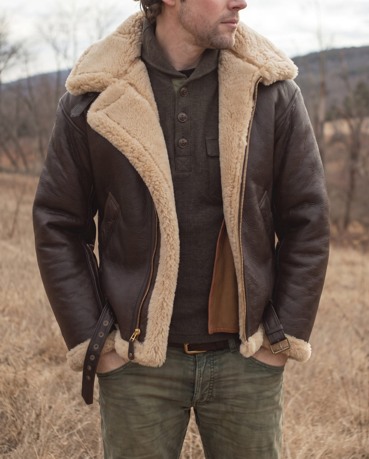 A man wearing a brown leather aviator jacket with shearling lining, a full-zip front, and plush shearling collar