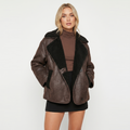Oversized brown leather aviator jacket with a plush black sherpa collar, wide lapels, and front patch pockets.