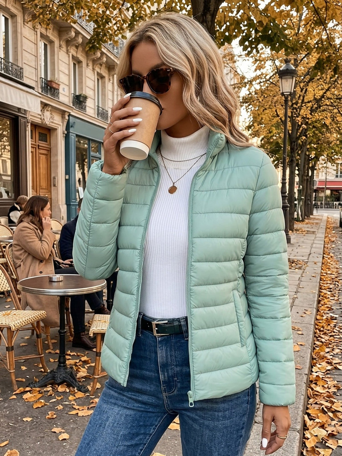 Mint green lightweight puffer jacket with slim channel quilting, stand collar, and zip front worn over a white turtleneck.
