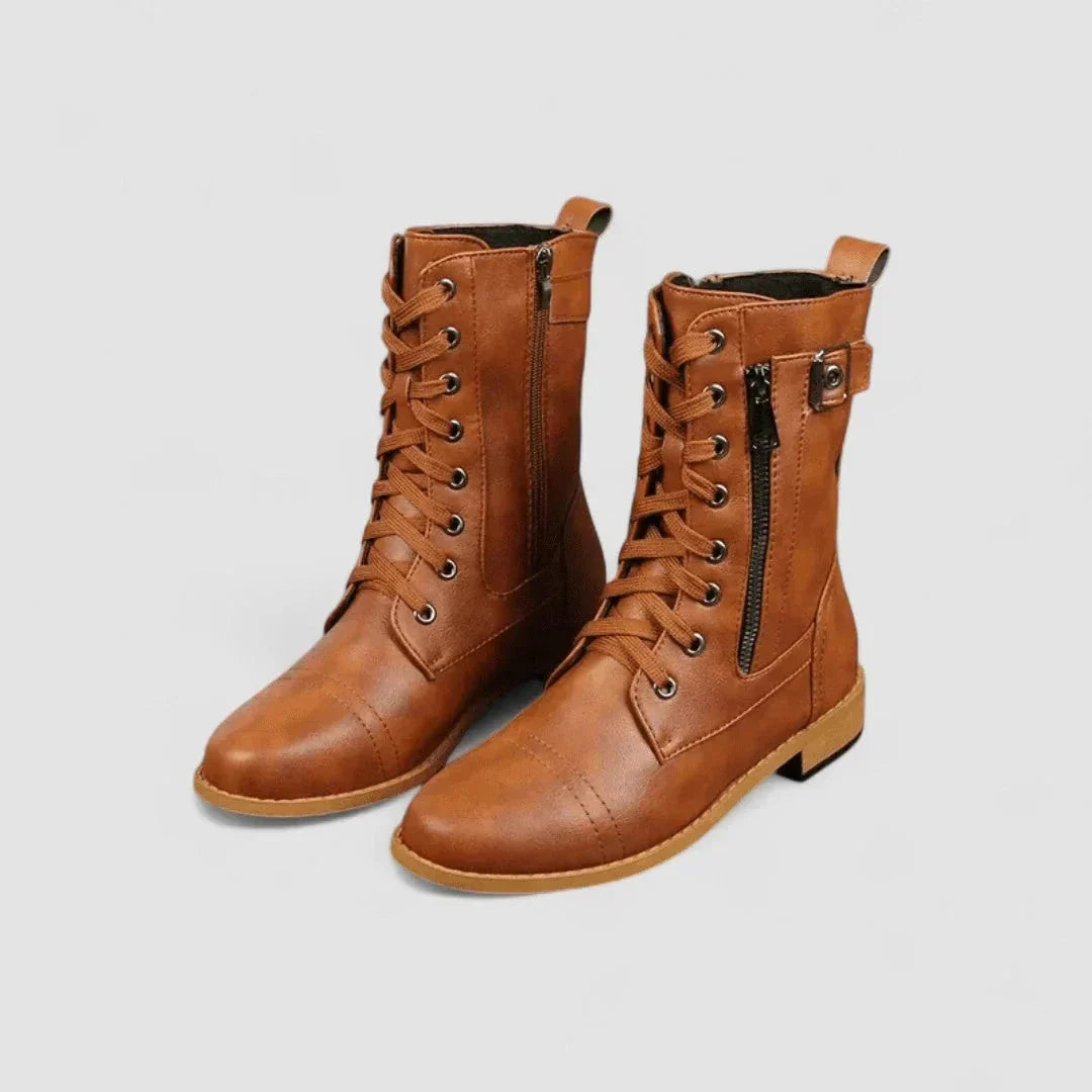 Tan grained mid-calf combat boots with lace-up front, side zip entry, cap toe, and adjustable buckle strap.