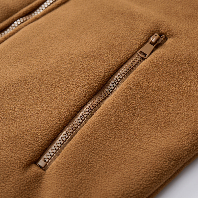 Close-up of a tan polar fleece jacket featuring a smooth, dense texture and a matching zippered side pocket.