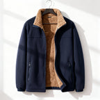 Navy blue polar fleece jacket with a plush tan sherpa lining and stand collar, hanging on a hanger.