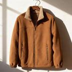 Tan polar fleece jacket with a plush sherpa-lined stand collar, zip-front closure, and elasticized cuffs hanging on a hanger.