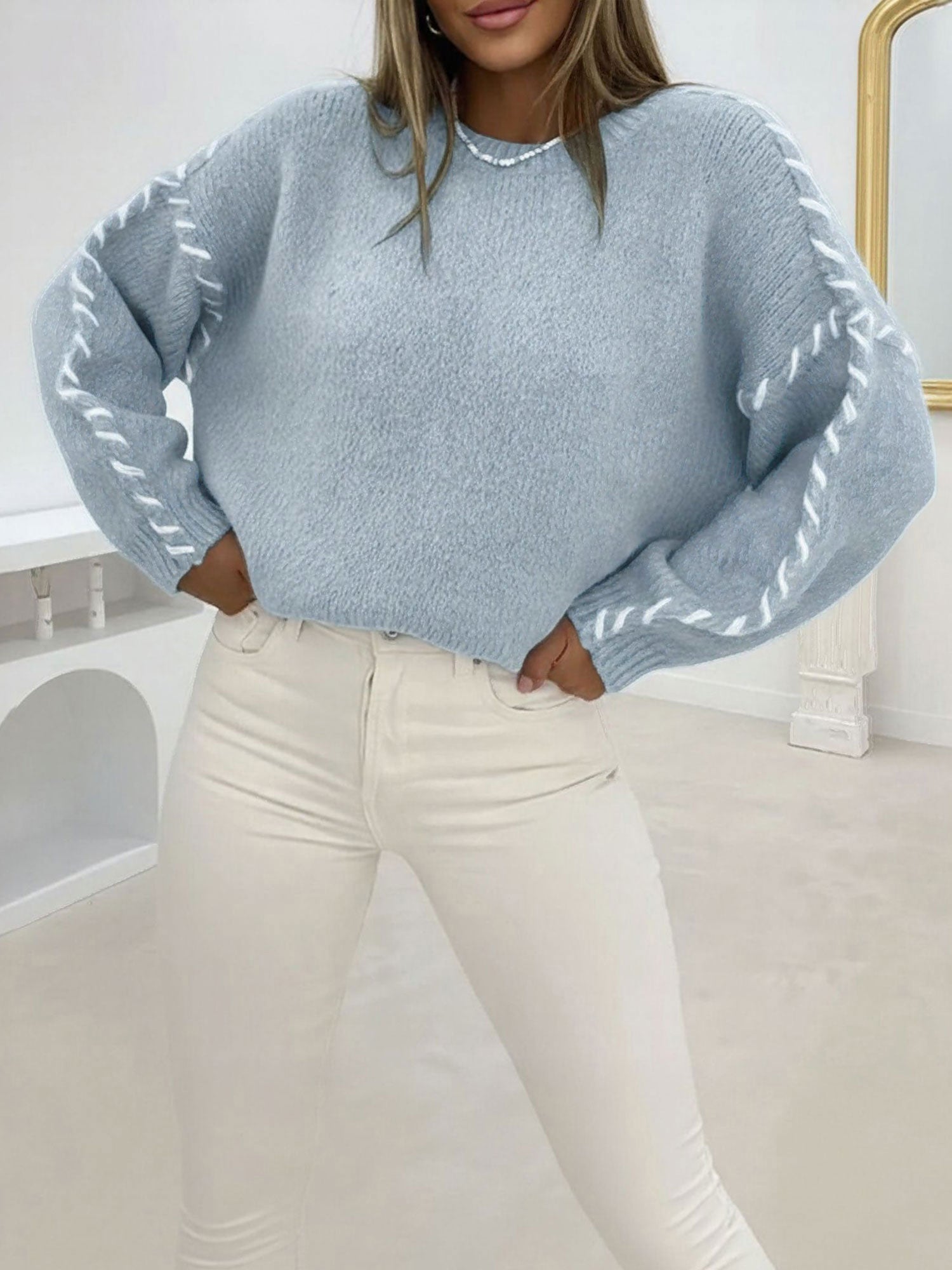 Light blue oversized crew-neck sweater in soft textured knit with contrast white whipstitch detailing on the sleeves.