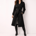 Black longline double-breasted trench coat in polyester twill with a belted waist, buckled cuffs, and checked lining.