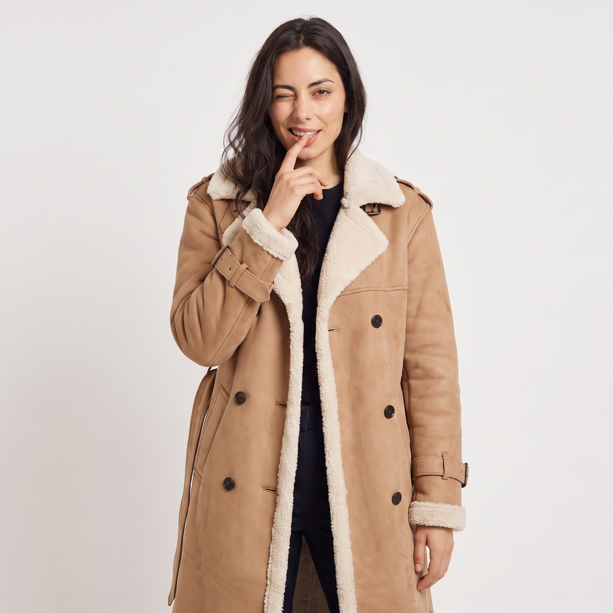 Close-up of a woman wearing a tan longline leather aviator coat, showing the borg-trimmed collar and tie waist