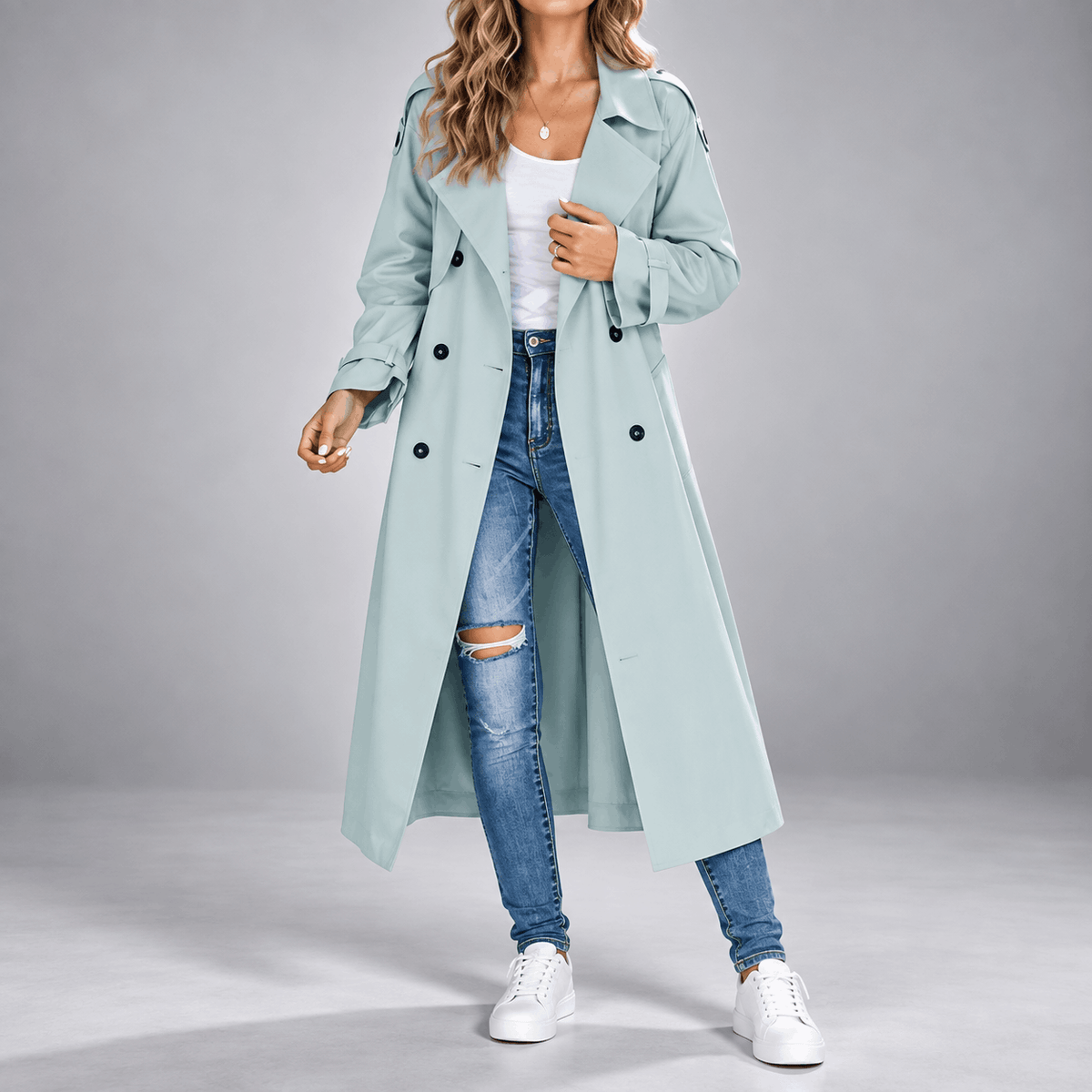 Light blue longline trench coat with double-breasted buttons, wide lapels, and an oversized fit worn over jeans.