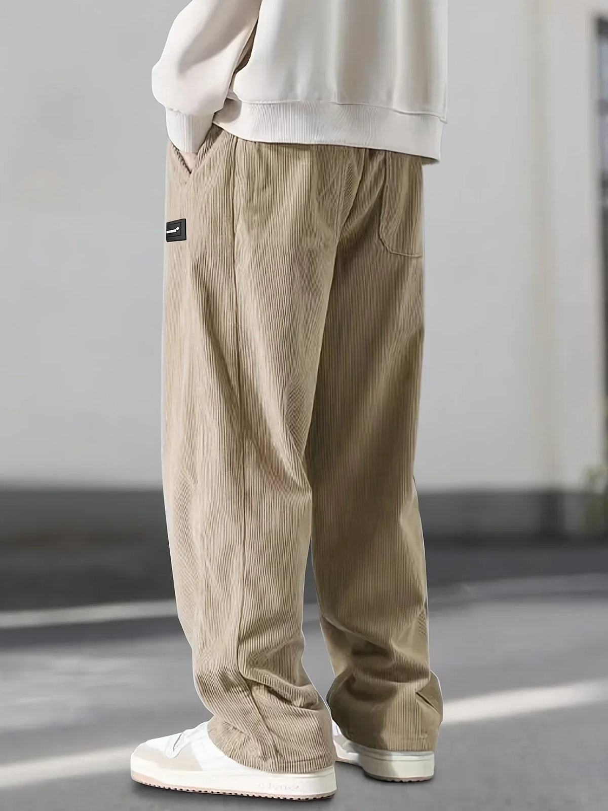 Loose-fit beige corduroy pants featuring a textured ribbed fabric, slant side pockets, and a relaxed straight-leg cut.