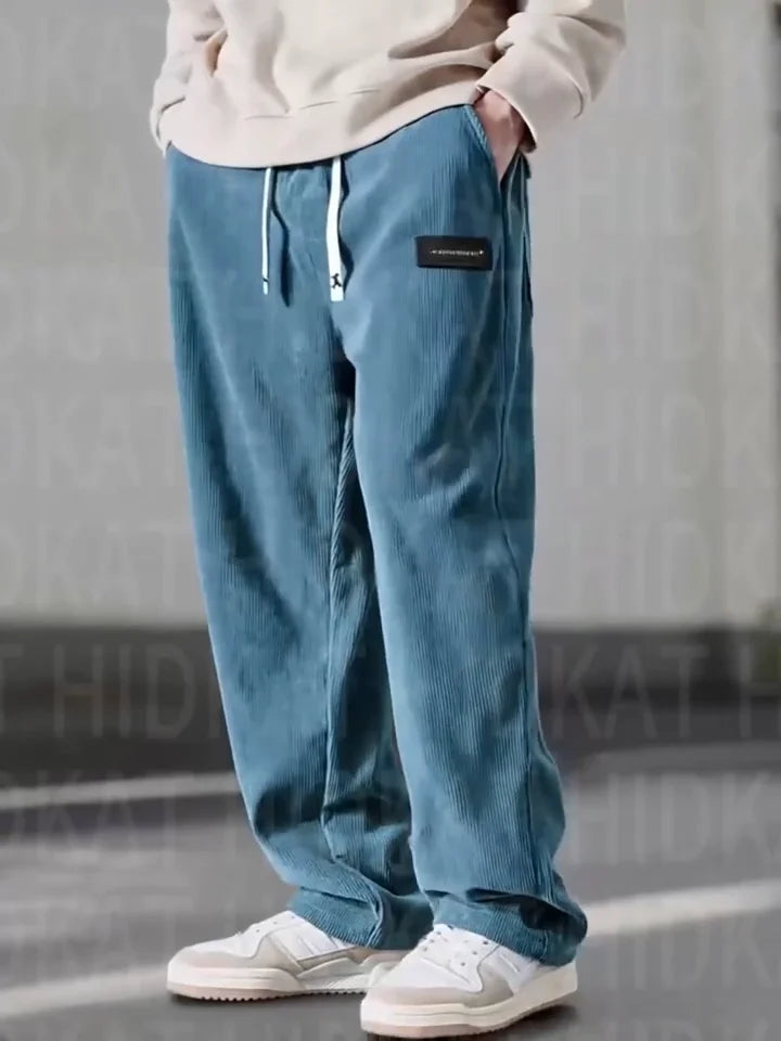 Blue loose-fit corduroy pants featuring an elastic drawstring waist, slant pockets, and a relaxed straight-leg silhouette.