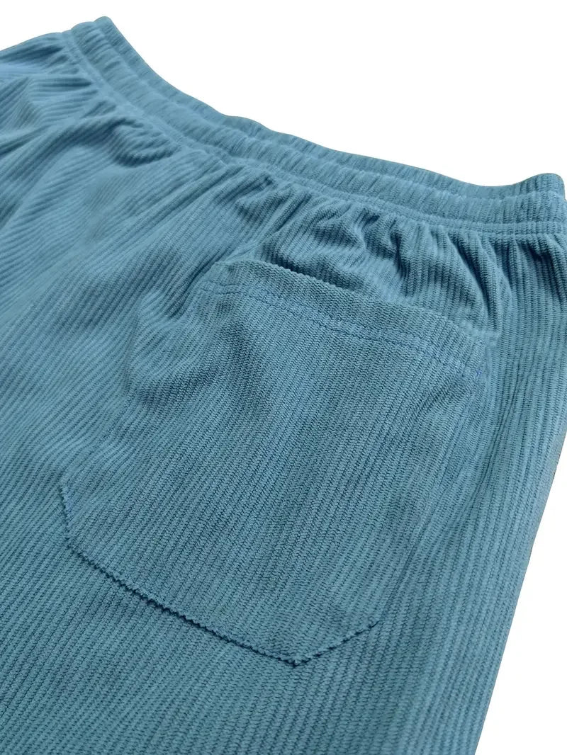 Blue corduroy pants featuring a textured ribbed fabric, elastic waistband, and a deep back patch pocket.
