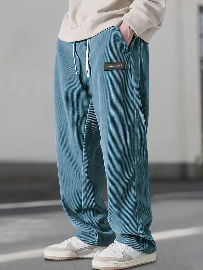 Blue corduroy pants with a loose, straight-leg fit, drawstring elastic waist, and slant side pockets.