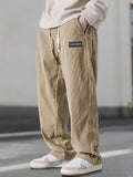 Beige loose-fit corduroy pants with an elastic drawstring waist, slant pockets, and a relaxed straight-leg silhouette.