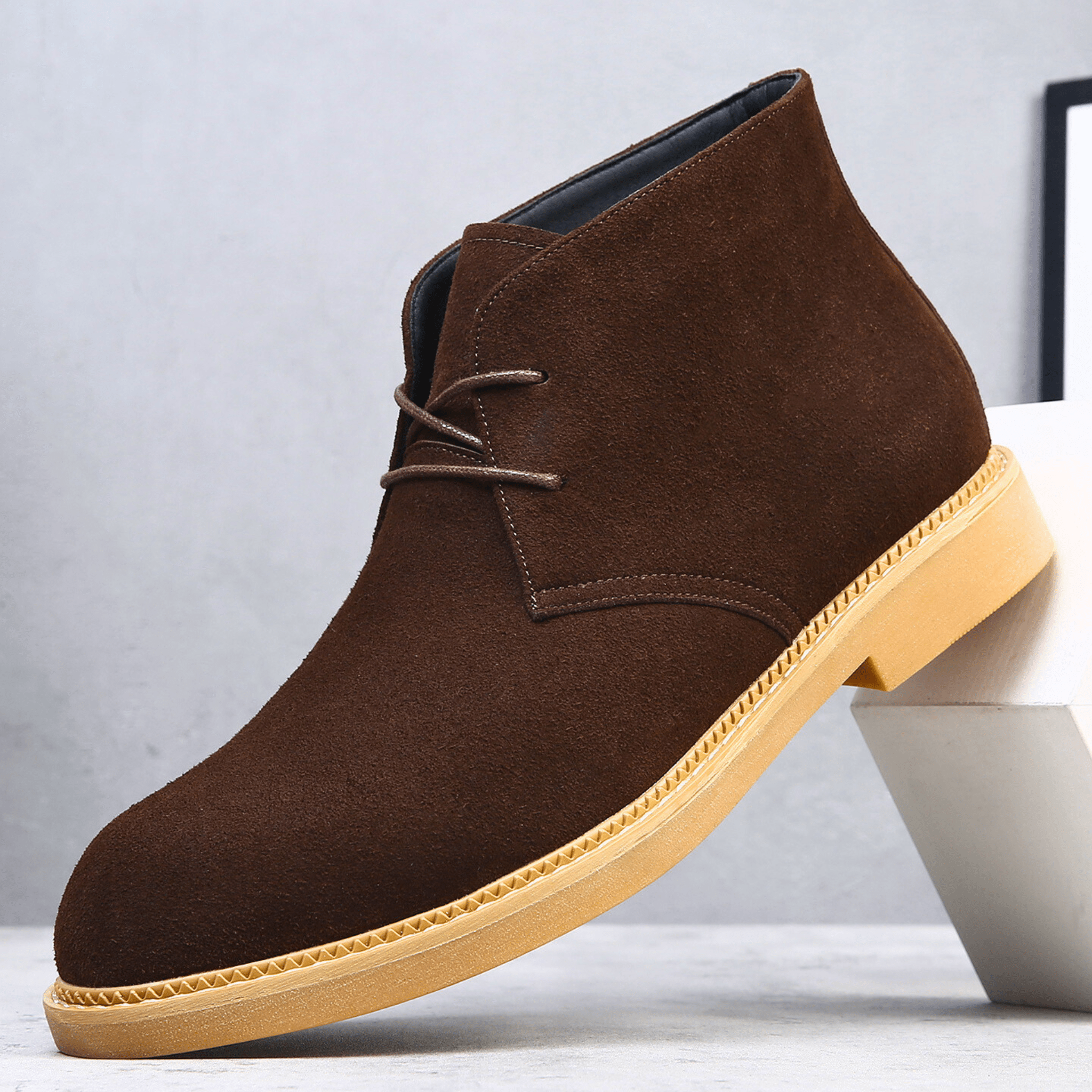 Dark brown suede-look desert boot with a plain toe, two-eyelet lace-up closure, and a contrast tan welt-stitched sole.