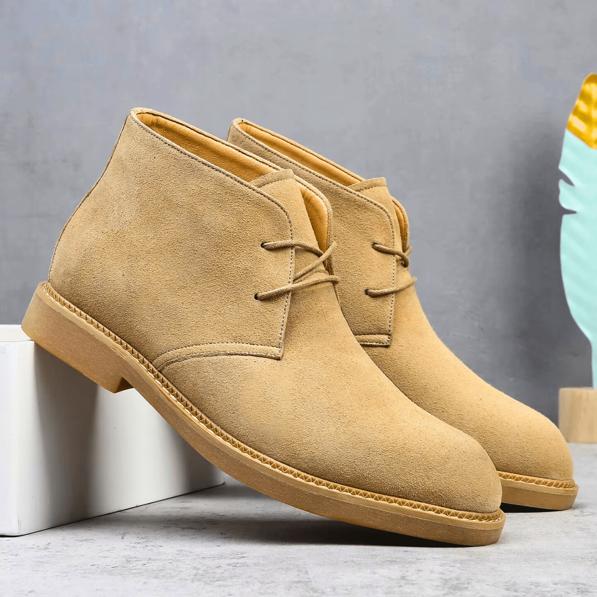 Tan suede-look desert boots with a plain toe, two-eyelet lacing, and a low stacked heel with visible welt stitching.