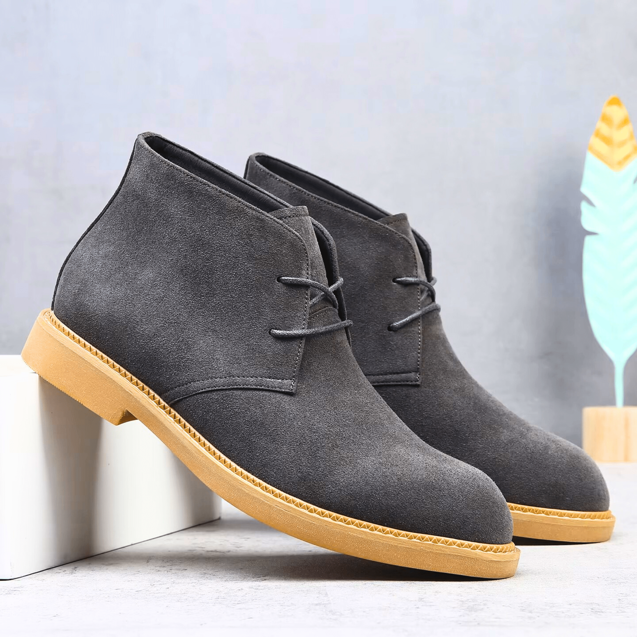 Charcoal grey suede-look desert boots with a plain toe, two-eyelet lacing, and a contrasting tan welted sole.
