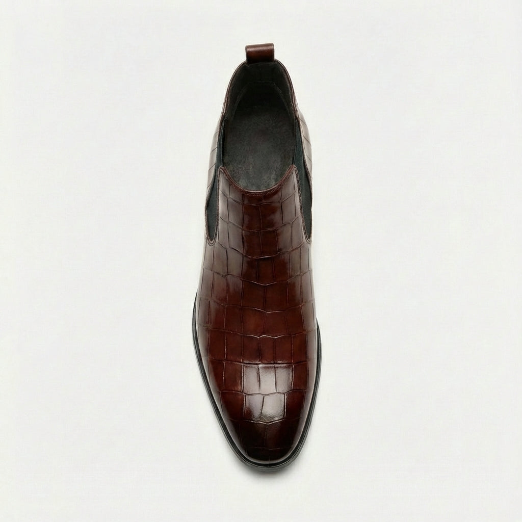Dark brown croc-embossed Chelsea boots with a pointed toe, slim outsole, and black elastic side gore.