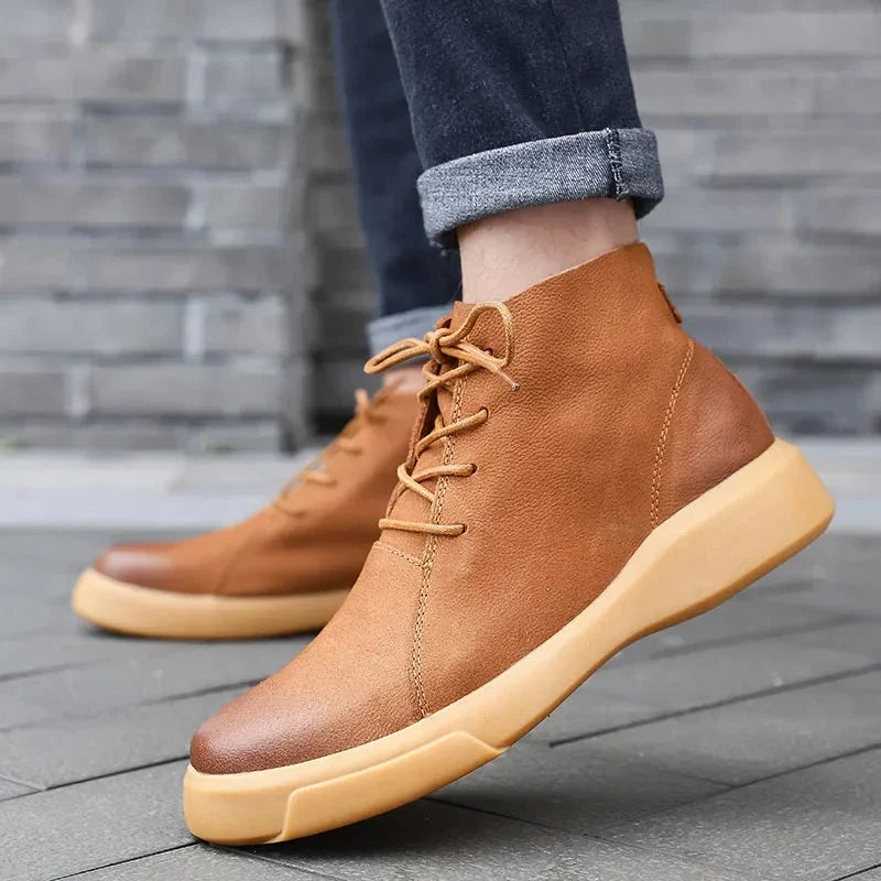 Tan leather chukka boots featuring a smooth finish, rounded toe, lace-up closure, and a thick, chunky rubber outsole.
