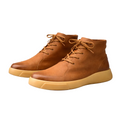 Tan smooth leather chukka boots with a rounded toe, lace-up closure, and a thick, chunky rubber outsole.