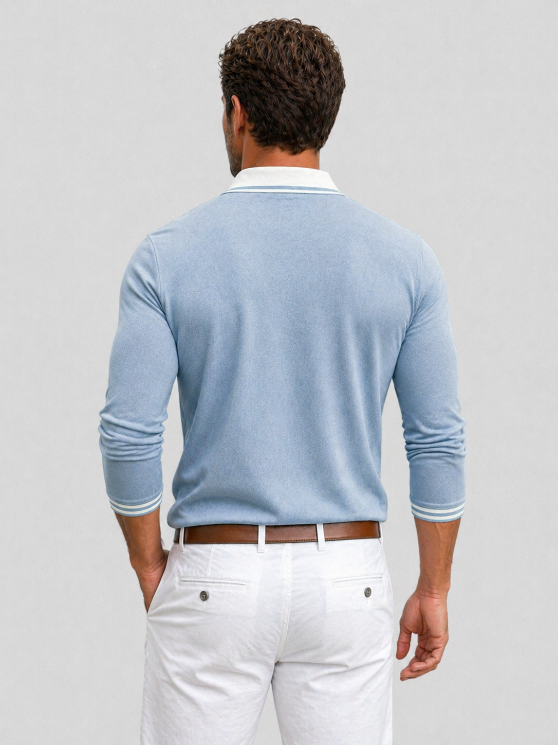 Light blue long-sleeve knit polo with a white contrast collar and striped cuff trim, worn tucked into white trousers.
