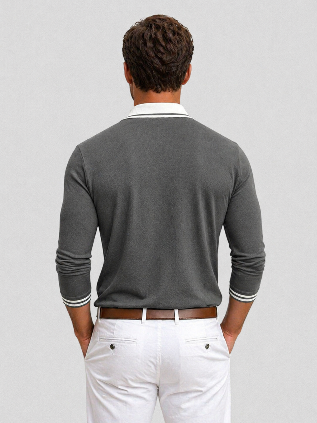 Grey long-sleeve knit polo with a white contrast collar and striped cuff trim, worn tucked into white trousers.