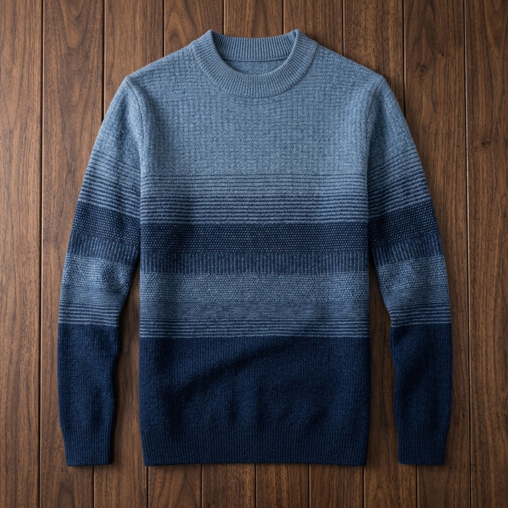 Fine wool crewneck sweater featuring a blue-to-navy ombre stripe pattern with ribbed collar, cuffs, and hem.