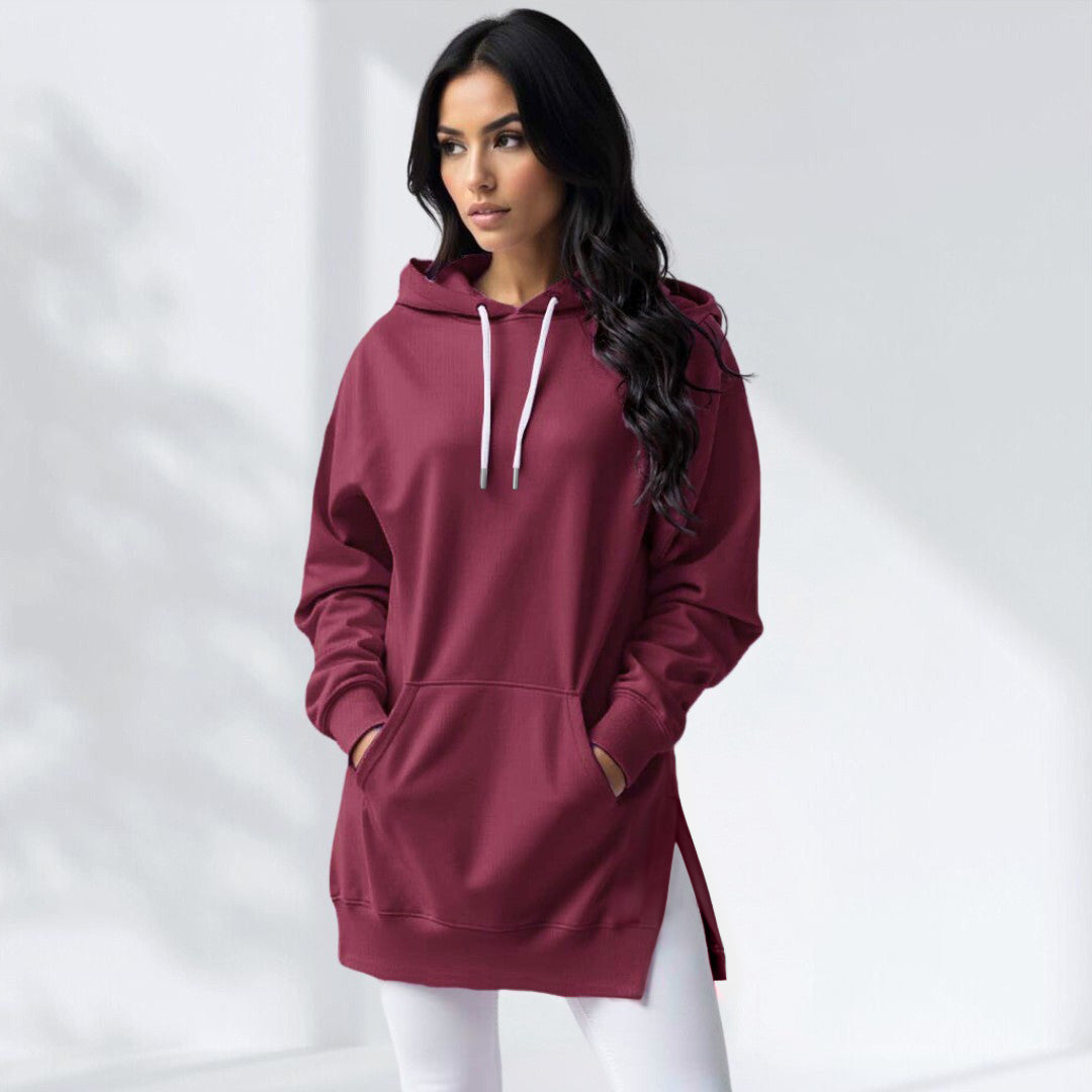 Burgundy oversized brushed cotton hoodie with a drawstring hood, kangaroo pocket, and side-slit hem worn over white leggings.