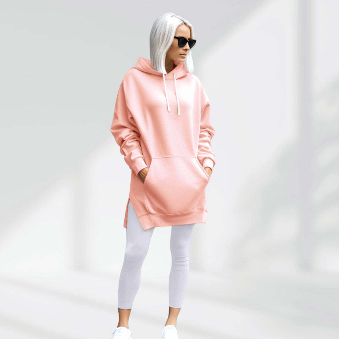Oversized blush pink brushed cotton hoodie with a longline silhouette, drawstring hood, and side-slit hem.