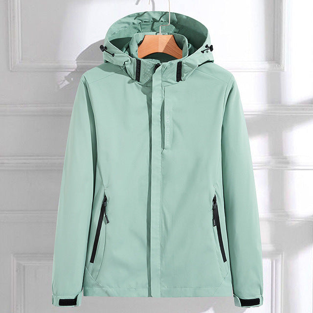 Mint green hooded waterproof jacket with a full-zip closure, adjustable hood, zippered pockets, and long sleeves displayed on a white background.
