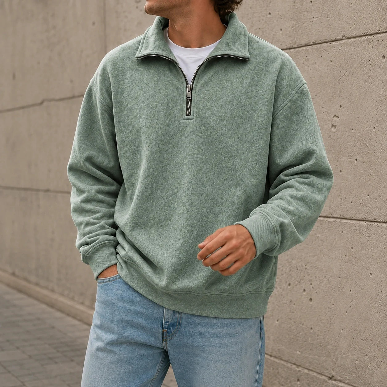 Sage green quarter-zip fleece sweatshirt with a stand collar and relaxed fit, paired with light blue jeans in a casual outdoor setting.