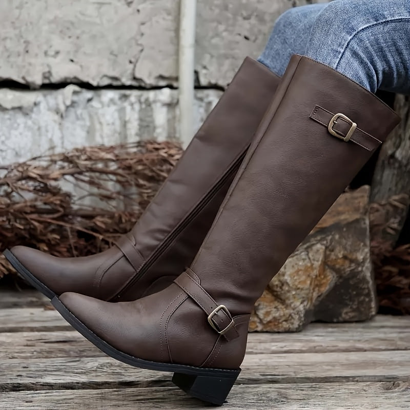 Brown knee-high boots with structured shafts, antique buckle straps, pointed toes, and stacked block heels.