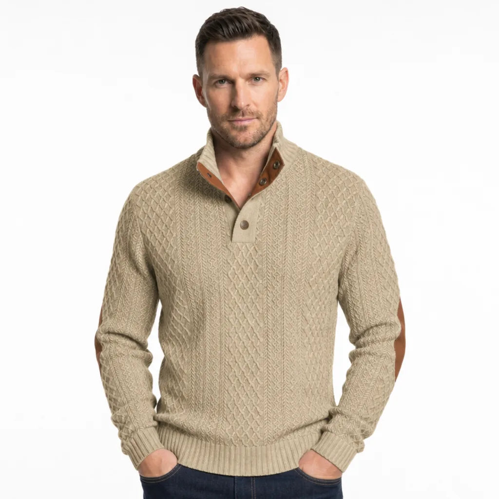 Tan cable-knit henley sweater featuring a mock neck button placket and contrast elbow patches on a model.