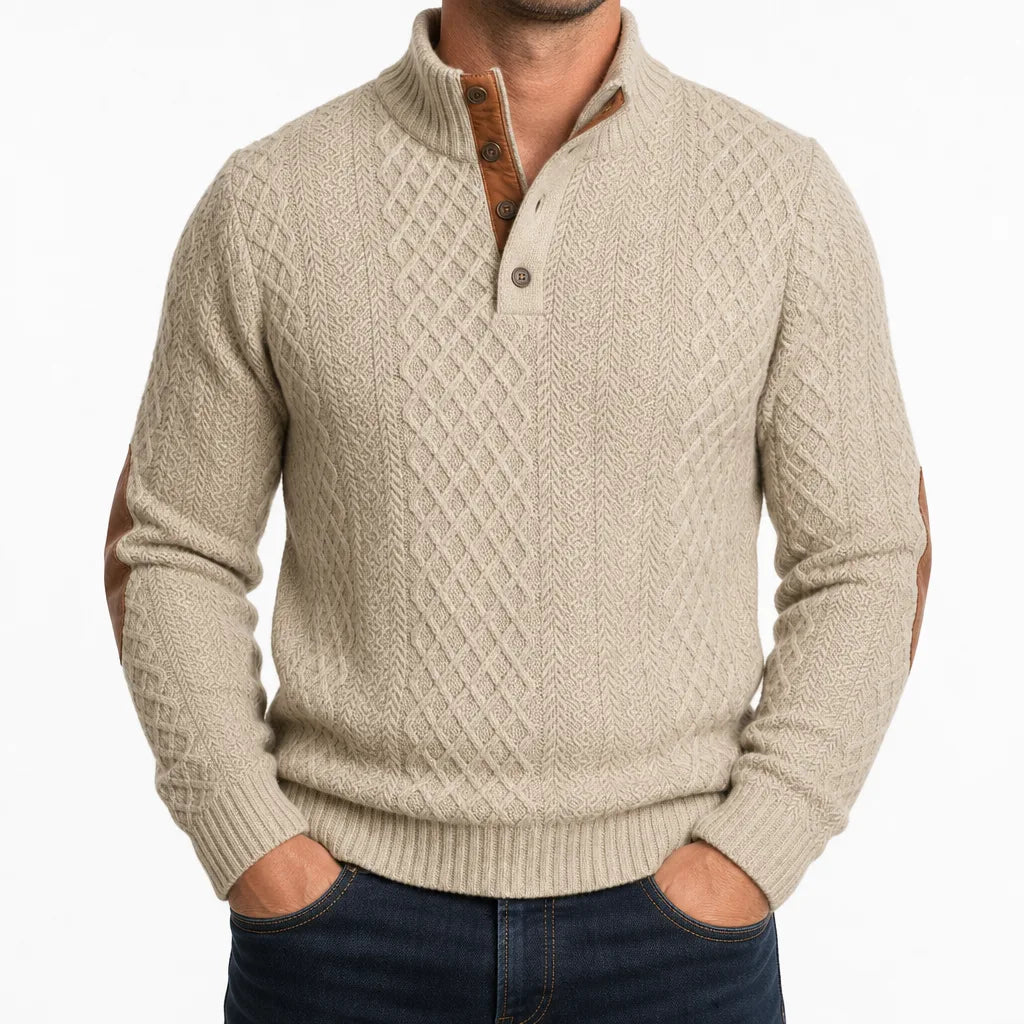 Beige cable-knit henley sweater with a mock neck, button placket, and brown contrast elbow patches.