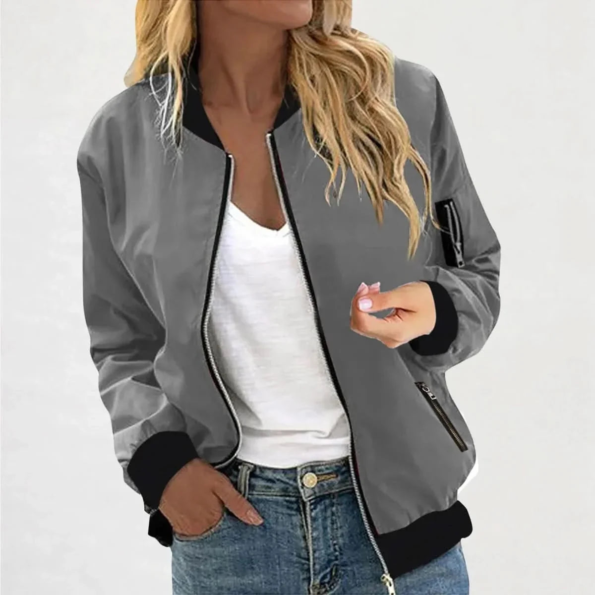 Woman wearing a charcoal gray bomber jacket with a full-zip closure, ribbed cuffs, and a casual fit.