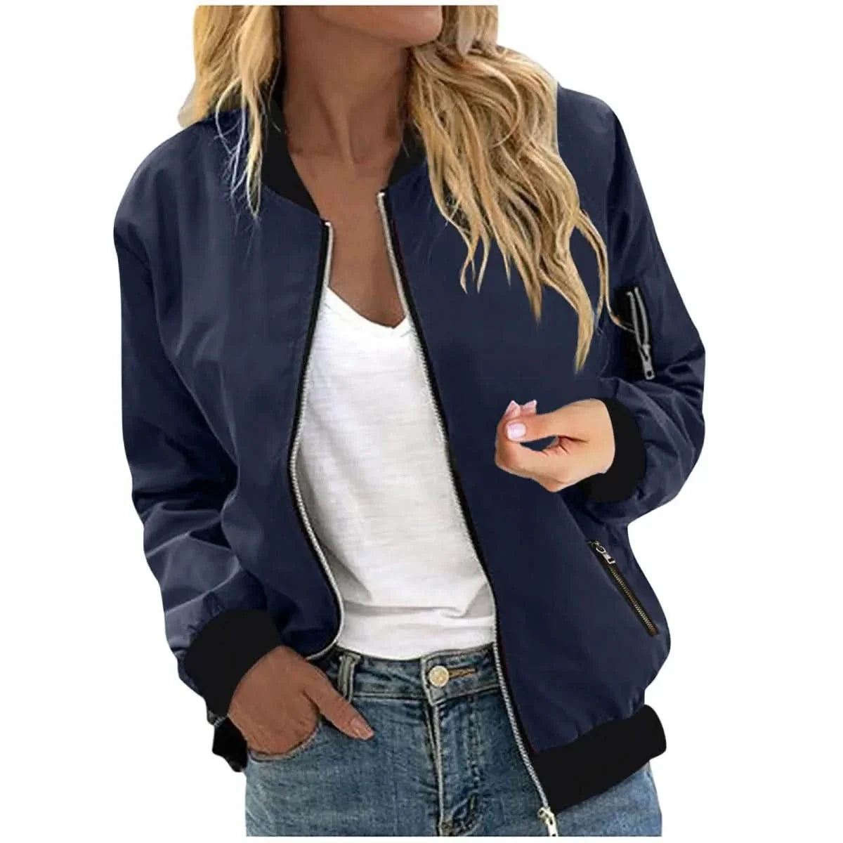 Woman wearing a navy bomber jacket with a zip-front closure, ribbed cuffs, and ribbed hem over a white tank top and blue jeans.