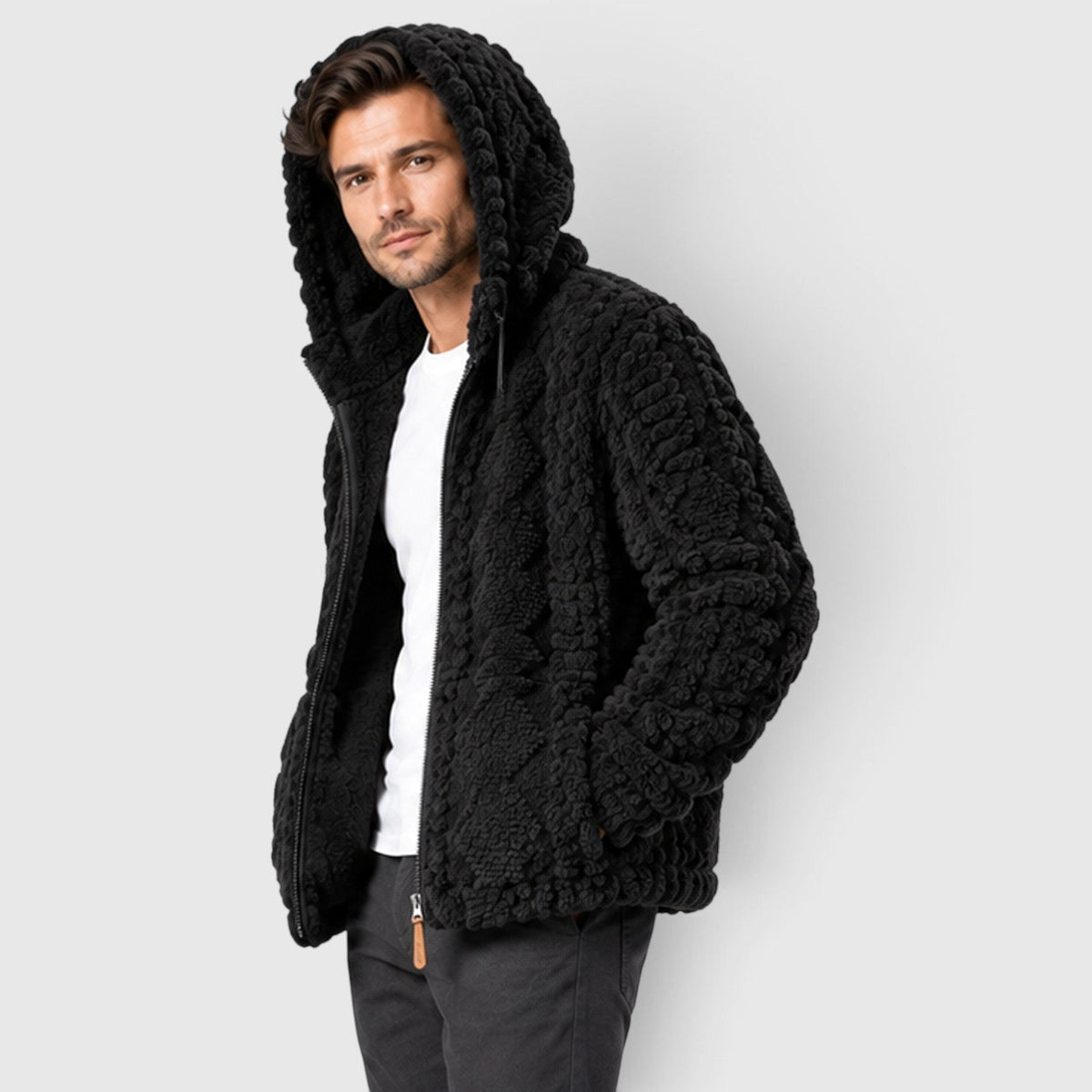 Side angle of a man wearing a black cable-textured fleece jacket with the hood raised.