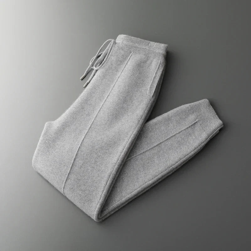 Gray merino wool trousers featuring a relaxed straight-leg fit, tapered ankle, and an adjustable drawstring waist.