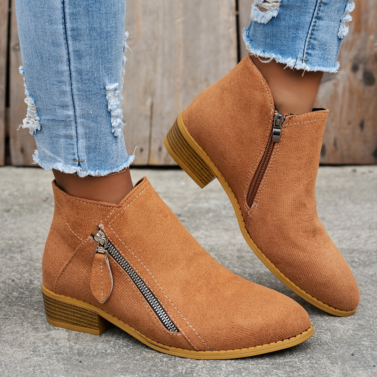 Tan brushed-finish almond toe booties with a low block heel and an exposed diagonal side zipper.