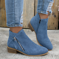 Blue brushed suede low-cut booties featuring an angled side zipper, almond toe, and a stacked low block heel.